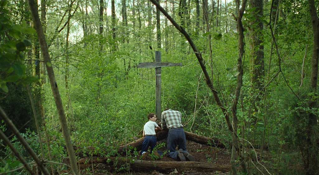 Willard Russell e Arvin Russell rezando ao pé da cruz.