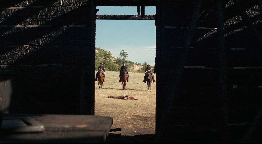 Capitão Blocker e dois de seus homens filmados através da porta do que sobrou da casa de Rosalee Quaid.