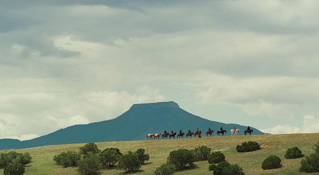 Plano aberto do grupo montado a cavalo.