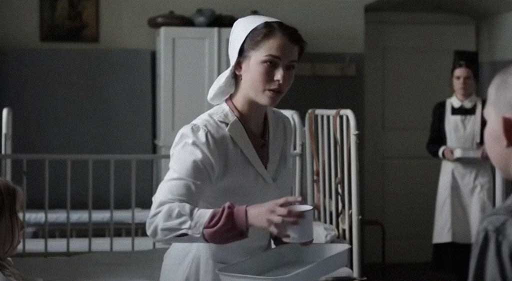 Infermeira Edith Kiefer recolhendo a caneca que Ernst derrubou.