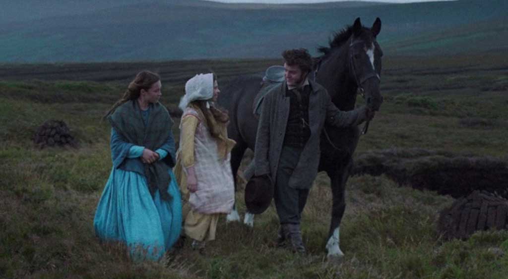 Lib Wright, Anna O'Donnell e Will Byrne caminham.