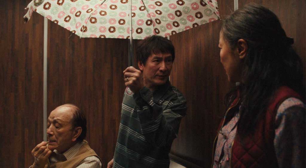 Alpha-Waymond e Evelyn Wang conversam no elevador.