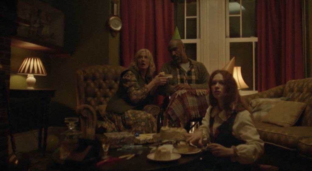 A família assustada observa as batidas repentinas na porta da residência.