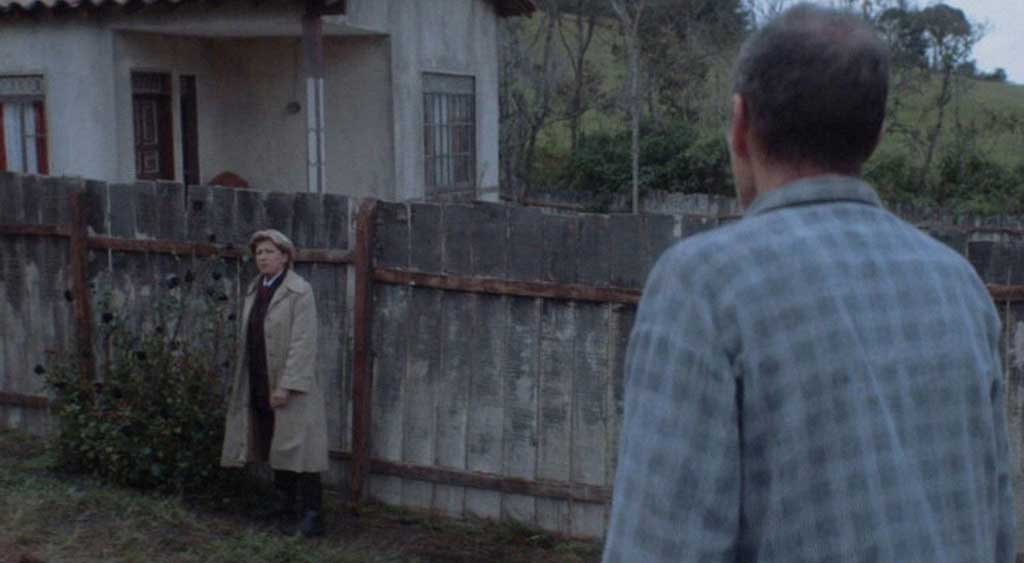 Sr. Polsky observa a advogada do novo vizinho lhe dizendo que as rosas precisam ser retiradas e plantadas em outro local por estar dentro da área que pertence ao seu cliente, o Sr. Herzog.