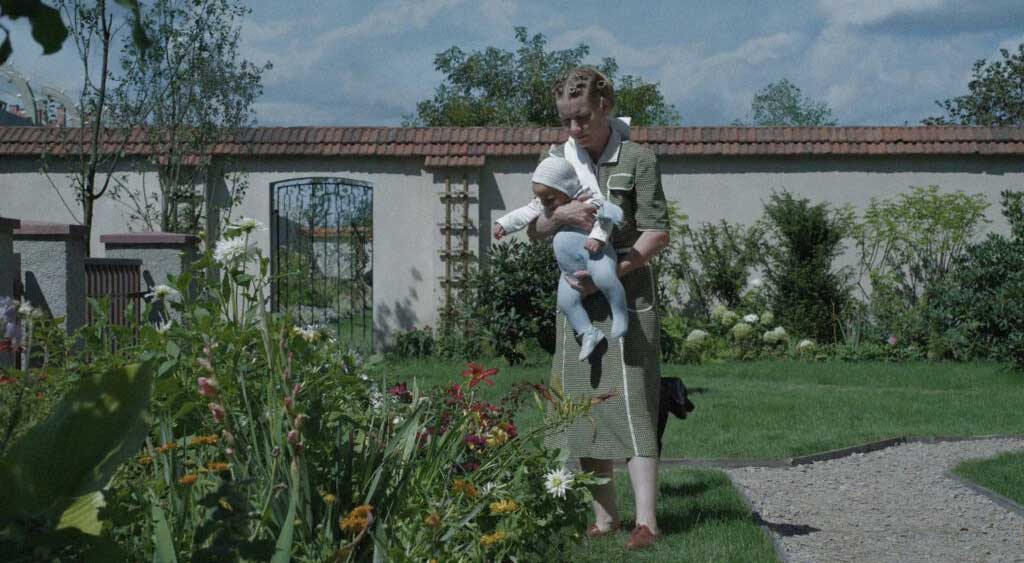Hedwig Höss mostra as flores coloridas do jardim para o seu bebê.