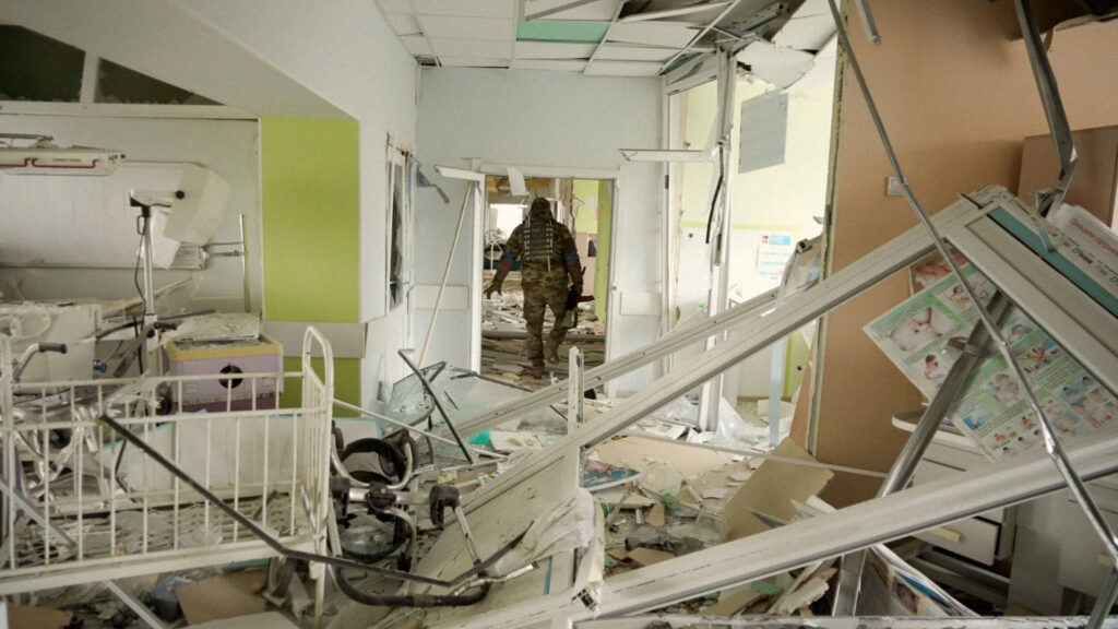 Soldado ucraniano caminha em meio aos descombros de um hospital quer servia como um centro cirúrgico e uma maternidade.