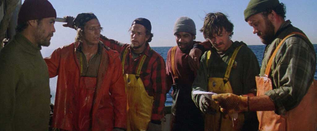 O capitão Billy Tyne recebe o mapa do Serviço de Meteorologia com o aviso da tempestade e entrega para seus homens.