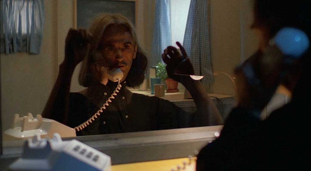 A face de Travis reflete no vidro espelhado sobrepondo o rosto de Jane do outro lado da cabine de peep-show. 