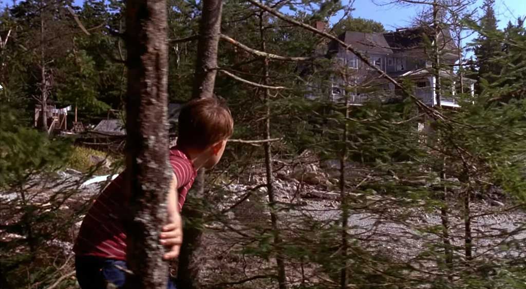 Chuck Norstadt acessa com medo a casa de Justin McLeod por entre os pinheiros que cercam os arredores da residência.