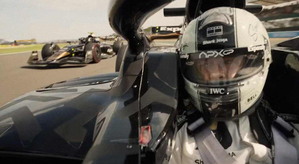 Sonny Hayes observa o seu companheiro de equipe, Joshua Pearce, investindo numa tentativa de ultrapassá-lo em plena corrida.