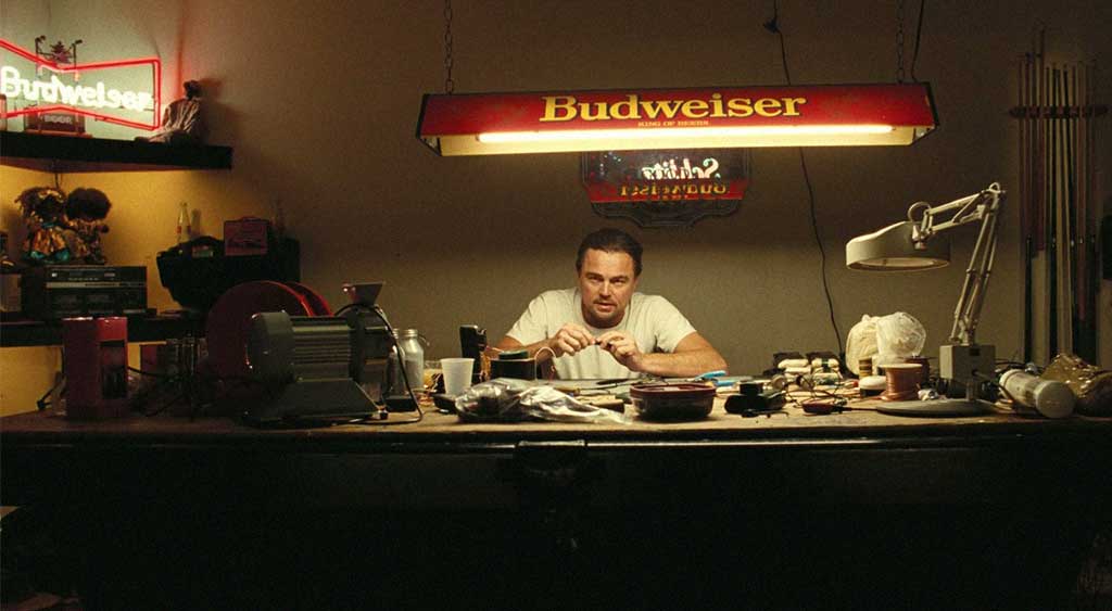 Bob (Leonardo DiCaprio) prepara a bomba que será plantada por Perfidia.