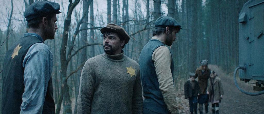 Durante uma parada no transporte dos judeus recém-chegados, provavelmente já mortos por asfixia no caminhão de gás, Wolf tenta passar um lápis para Solomon, que o recusa.